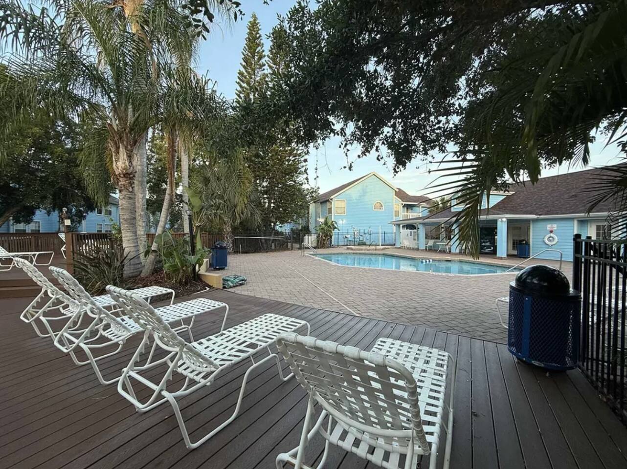 Resort pool deck with lounge chairs and palm trees in the Ellis Getaways community